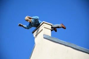 MAN BALANCING ON ROOF