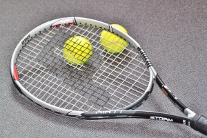 TENNIS RACKET WITH TWO BALLS SPEWED FROM BLACK HOLE
